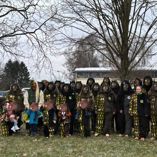 Die Moorgeischder im Häs vor einem winterlichen Baum: was für ein Team